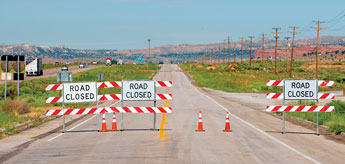 Signs on New Mexico Highway 118 warn motorists of the damage done to the road from heavy flooding Sunday. Heavy rains washed large amounts of mud and debris into the right of way, temporarily closing the road. © 2011 Gallup Independent / Brian Leddy